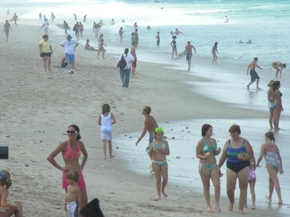 lots of people on the beach in the surf water and waves of the ocean in Florida
