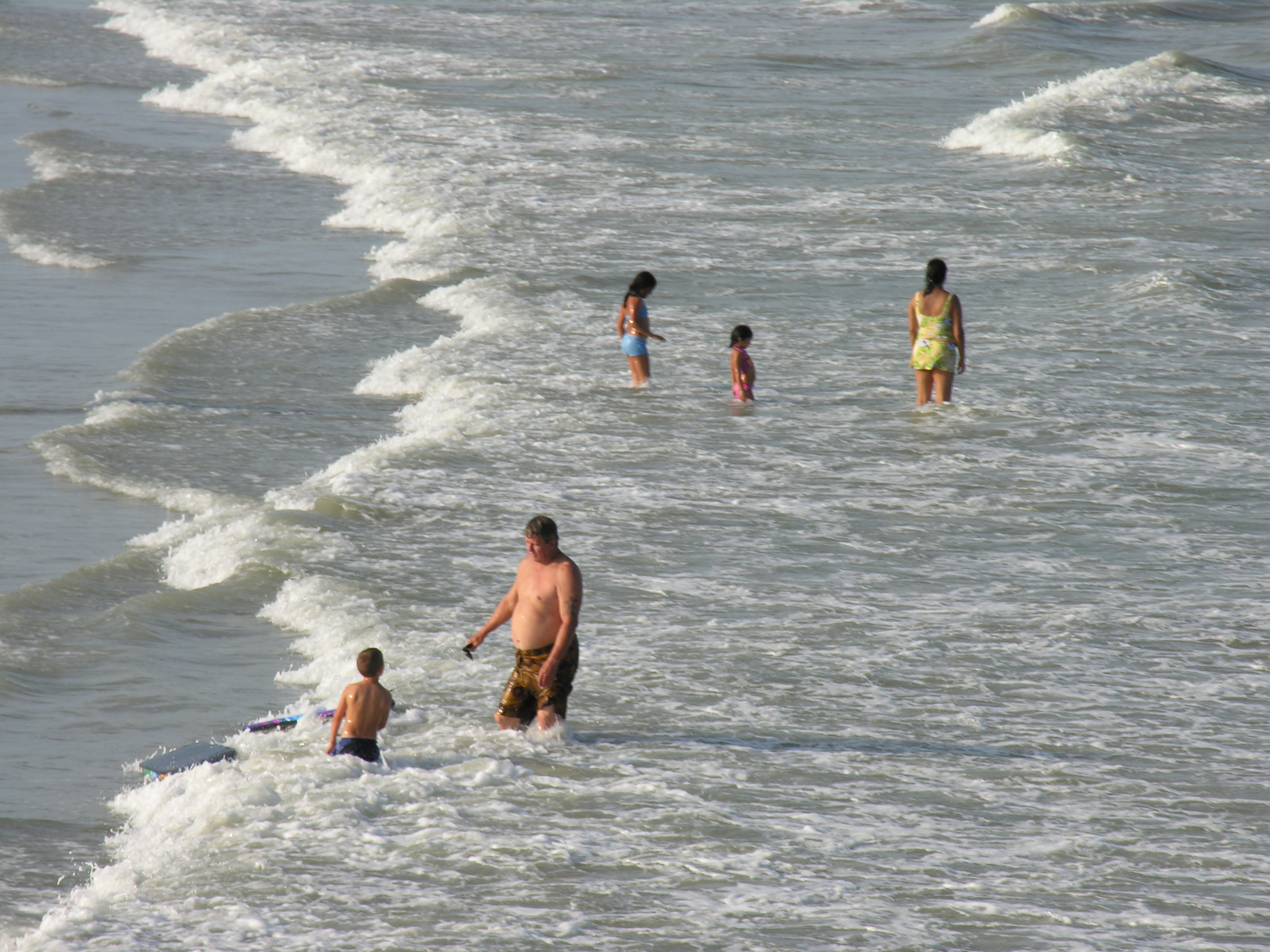 Family day at the beach rough seas high tide rip current big waves