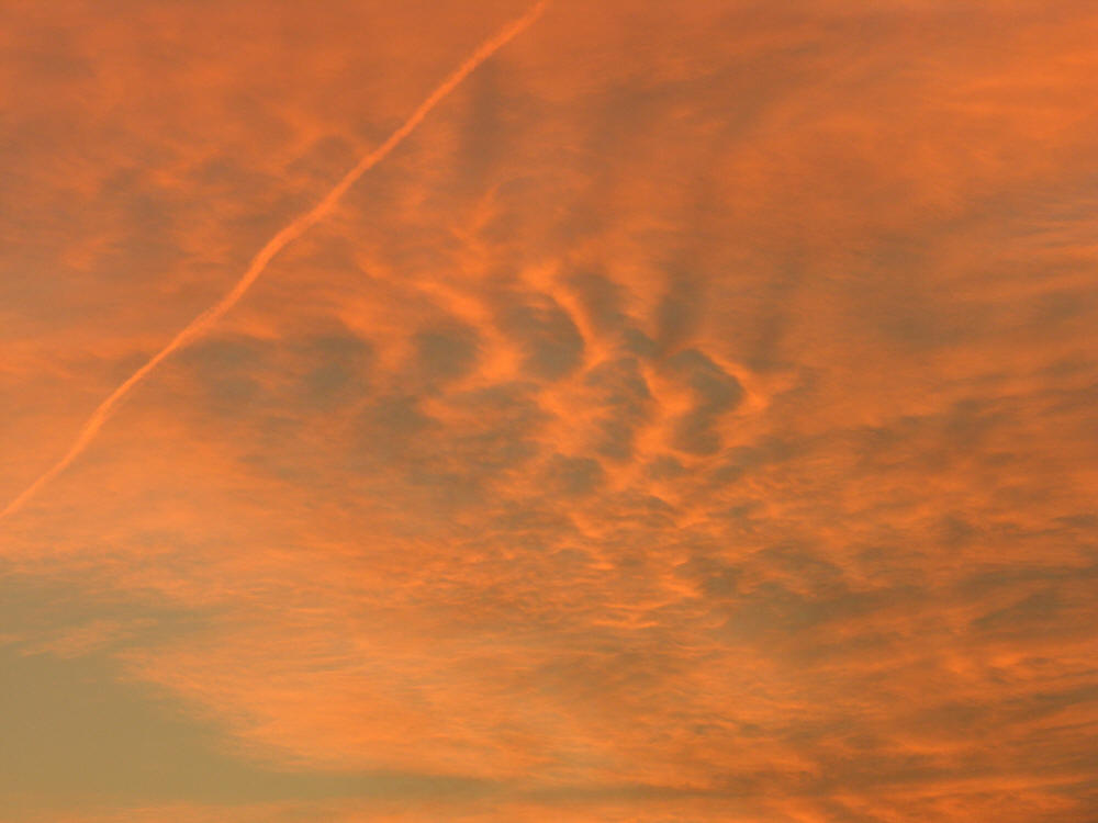 Orange sky at sunset with jet contrail West Palm Beach, Florida