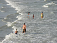 Family day at the beach rough seas high tide rip current big waves