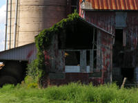 Rustic old red barn with grey weathered barnboard and concrete silo